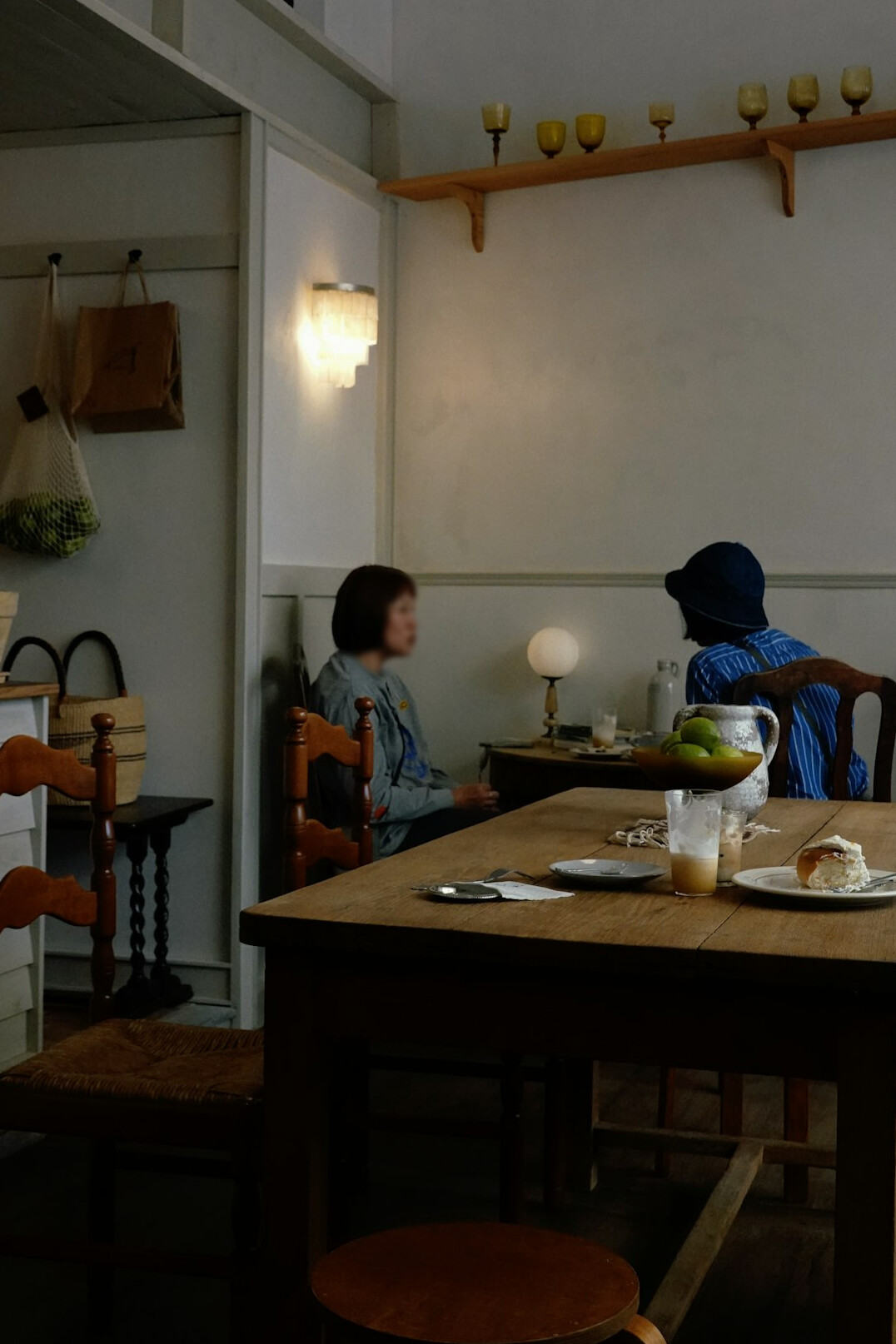 Two people in quiet conversation at a wooden table, interview setting